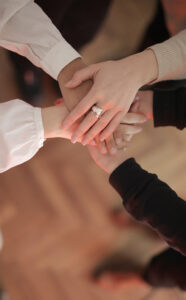 Mulheres empilhando a mão juntas em psicoterapia de grupo online